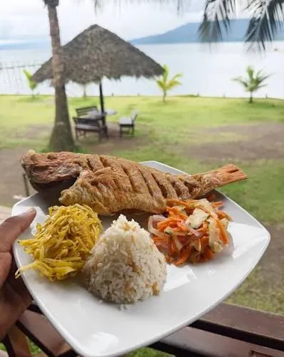 Pescado frito con arroz, patacón y ensalada frente al mar