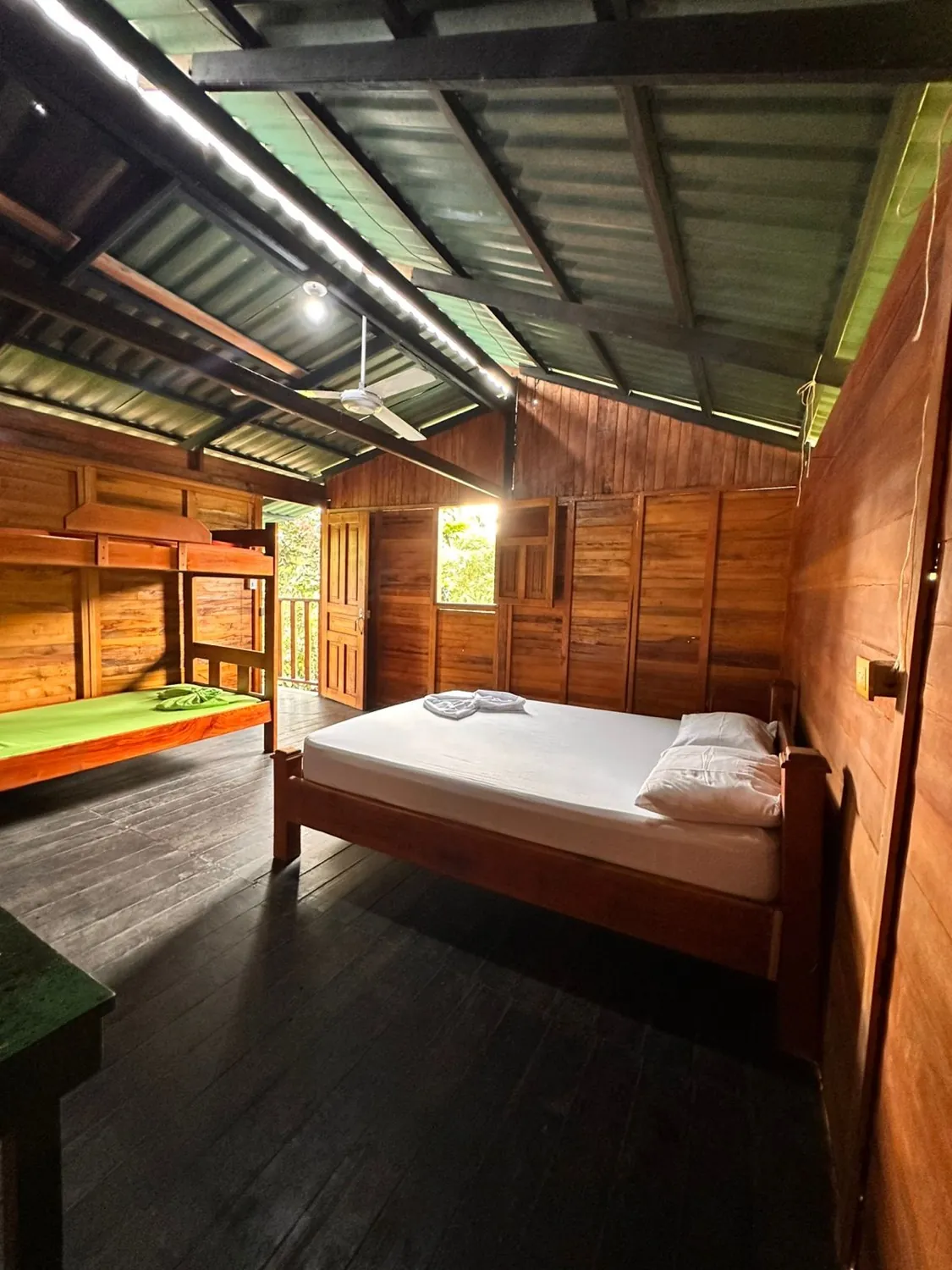 Habitación con cama doble y camarote, techo alto y ventilador
